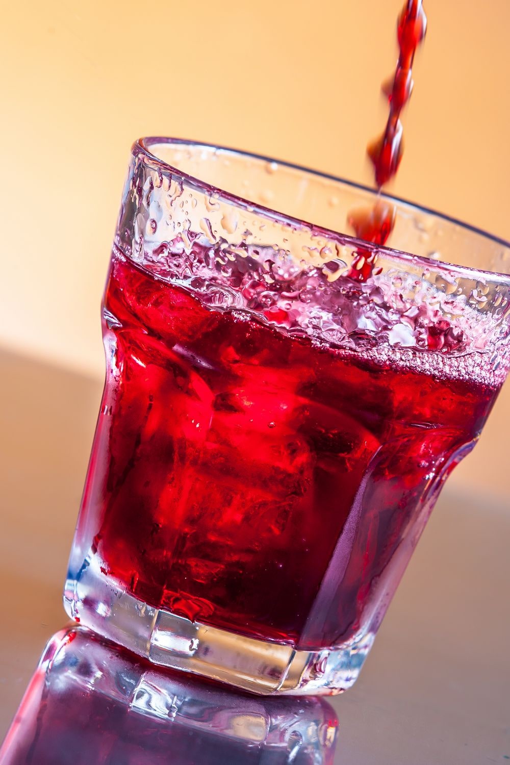 A glass of cold refreshing cranberry juice made mostly with water.