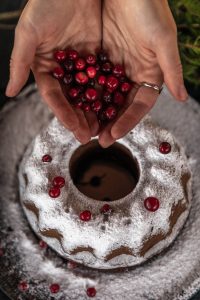 Round Christmas cake with fresh cranberries and icing sugar