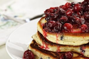 A delicious topping of fresh cranberry sauce over a stack of pancakes.