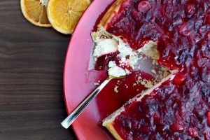 A delicious cheesecake with orange or lemon and topped with cranberry topping.
