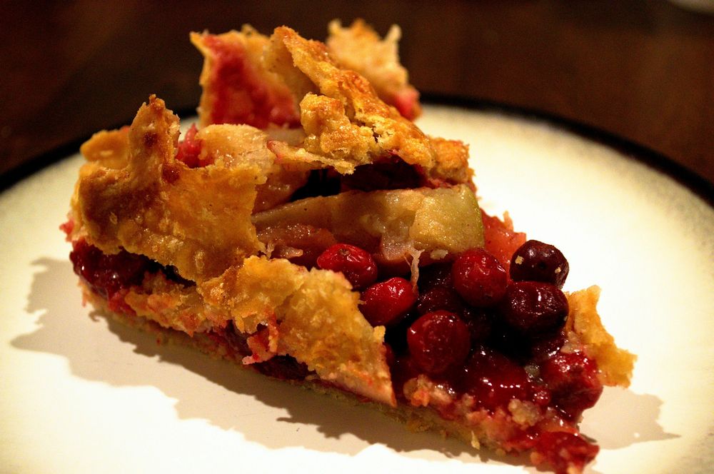 Flaky pie crust crumbling over cranberry rhubarb topping