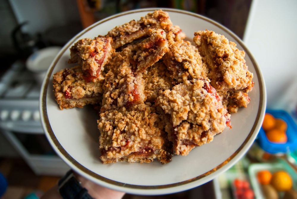 Crumble bars recipe with baked cranberry sauce inside oats and brown sugar.