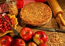 A crumble pie that is been freshly baked with apples and fresh raw cranberries.