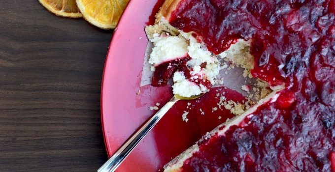 A delicious cheesecake with orange or lemon and topped with cranberry topping.