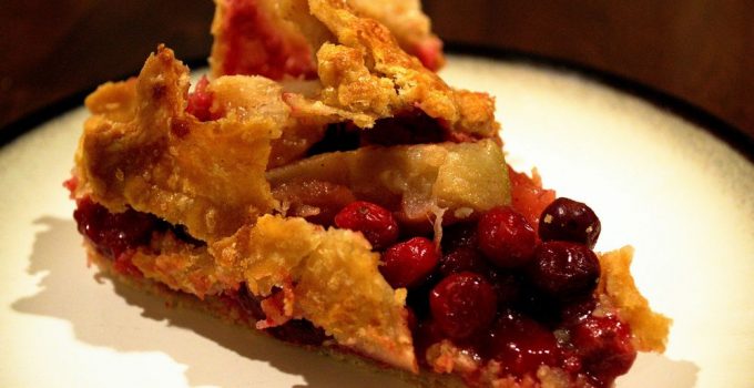 Flaky pie crust crumbling over cranberry rhubarb topping