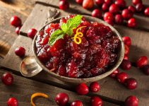 A bowl of homemade cranberry sauce with a slice of orange zest.