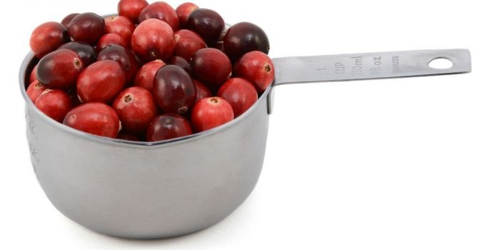 A Measuring cup of cranberries.